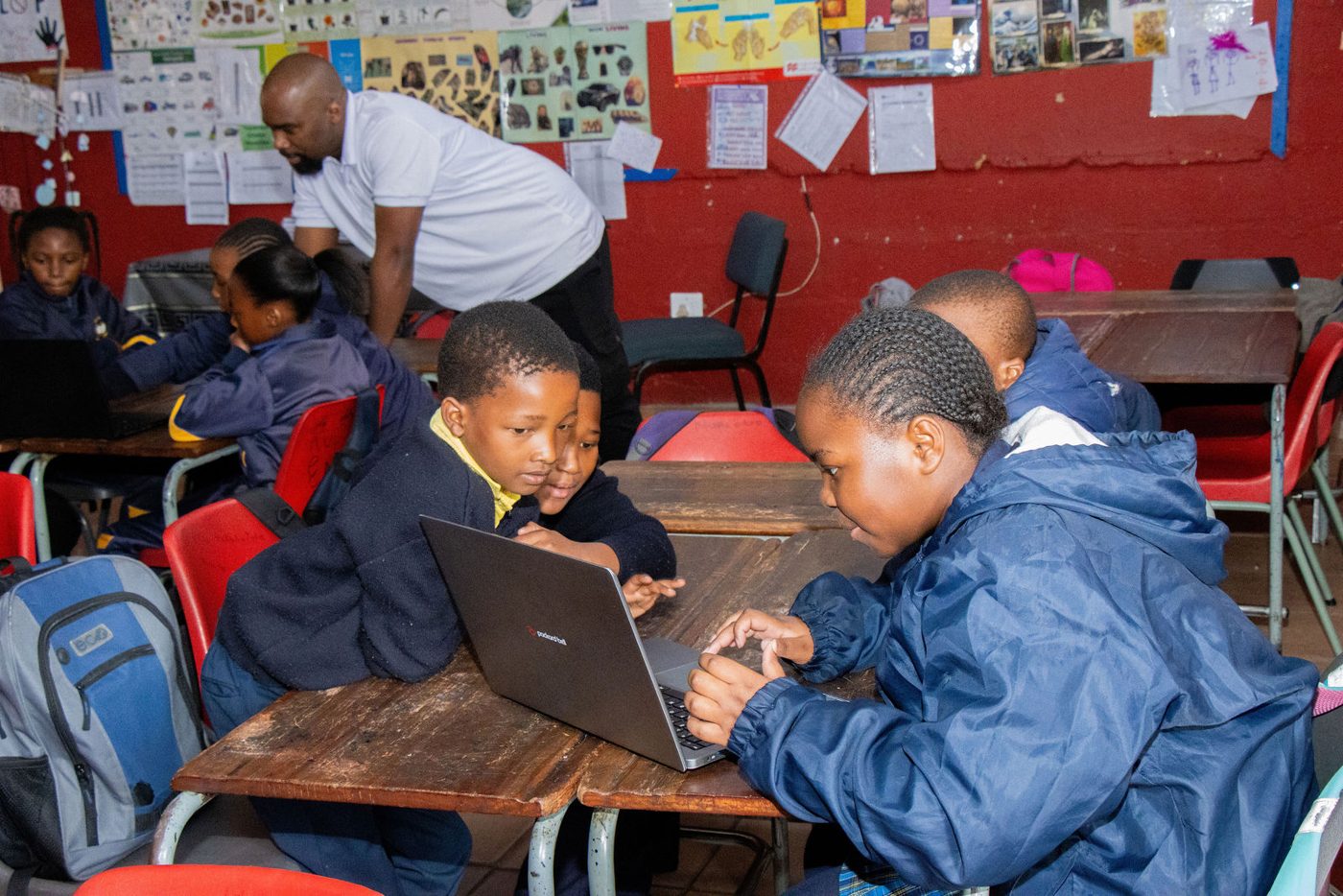A learner concentrating on a task at a laptop in the workshop room.